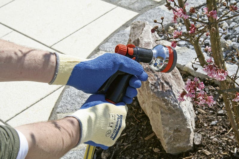PowerGrab Strickhandschuhe in Latex Anwendungsbild mit Wasserschlauch in der Hand